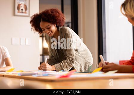 Au bureau, écrivant sur des notes adhésives, femme brainstorming idées dans la réunion d'affaires créative Banque D'Images