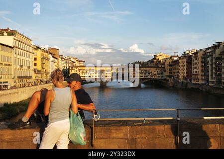 Florence, Italie. 11 septembre 2024. Un couple profite pendant le coucher du soleil au pont Santa Trinita avec le pont Vecchio (arrière-plan) sur la rivière Arno dans le centre historique de Florence le 11 septembre 2024. (Photo de Paulo Amorim/Sipa USA) crédit : Sipa USA/Alamy Live News Banque D'Images