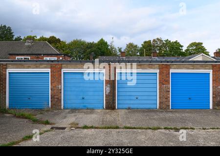 Une rangée de portes de garage peintes en bleu dans un bloc de garages près de South Ham Road, Basingstoke, Hampshire, Royaume-Uni. 11 septembre 2023 Banque D'Images