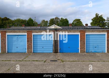 Une rangée de portes de garage peintes en bleu dans un bloc de garages près de South Ham Road, Basingstoke, Hampshire, Royaume-Uni. 11 septembre 2023 Banque D'Images