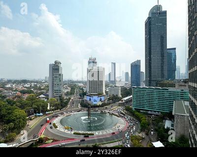 Vue sur le centre-ville de Jakarta, le quartier central des affaires et le célèbre rond-point Bundaran HI avec les gratte-ciel de Jakarta sous le ciel bleu ensoleillé. Banque D'Images