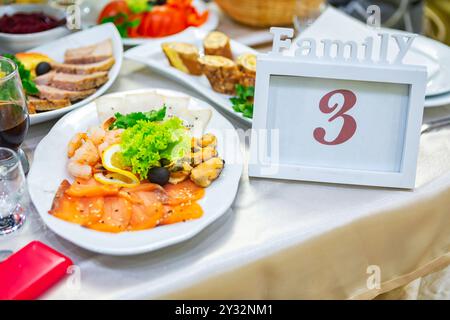 Table familiale avec plateau de fruits de mer et décor élégant lors d'un rassemblement de célébration. Banque D'Images