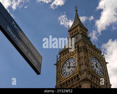 LONDRES, Royaume-Uni - 12 MAI 2012 : vue sur Big Ben et panneau indiquant l'abbaye de Westminster et Parliament Square face au ciel bleu Banque D'Images