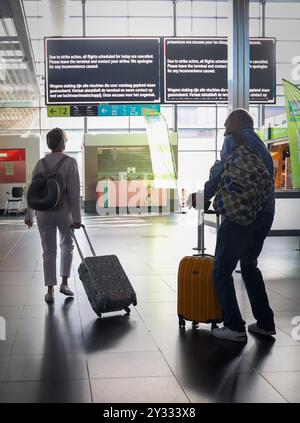 Charleroi, Belgique. 12 septembre 2024. Passagers regardant un écran d'information lors d'une grève à l'aéroport Brussels South Charleroi (BSCA) à Gosselies, Charleroi le jeudi 12 septembre 2024. L'horaire complet des vols du jeudi matin a été annulé, après une grève du personnel opérationnel. BELGA PHOTO VIRGINIE LEFOUR crédit : Belga News Agency/Alamy Live News Banque D'Images