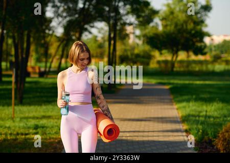 Elle marche en toute confiance dans le parc, se préparant pour sa séance de yoga. Banque D'Images