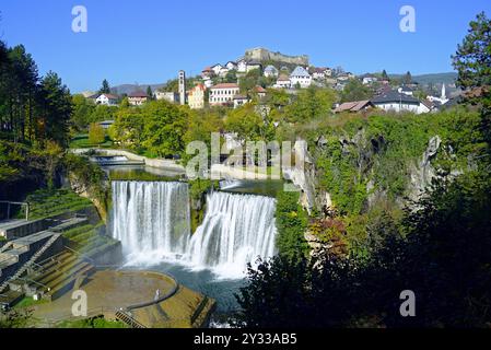 Vue sur la vieille ville de Jajce avec des maisons traditionnelles et une ancienne forteresse au sommet d'une colline, et la haute cascade de Pliva en dessous Banque D'Images