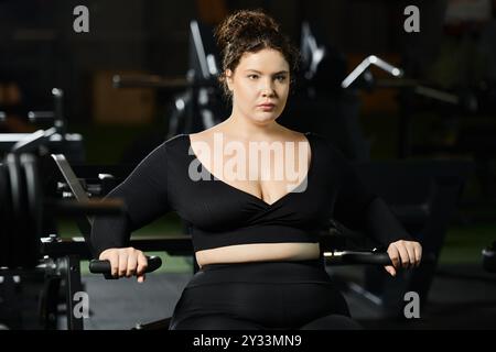 Une femme de grande taille embrasse sa force tout en faisant de l'exercice dans le gymnase, favorisant la positivité du corps et la santé. Banque D'Images