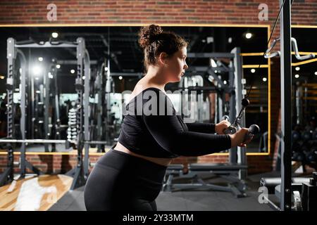 Une femme de grande taille s'entraîne en toute confiance, mettant en valeur sa force et sa positivité dans son parcours de remise en forme. Banque D'Images