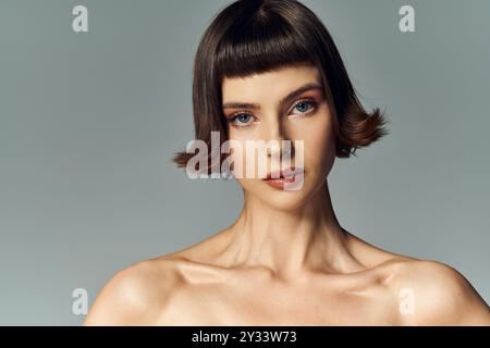 Une belle jeune femme présente une robe rouge audacieuse avec un grand noeud et les cheveux courts. Banque D'Images