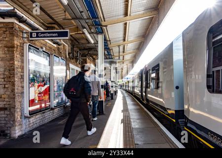 Les passagers marchent le long du quai alors qu'un train du South Western Railway se trouve sur le quai de la gare de Staines-upon-Thames dans le Surrey, au Royaume-Uni Banque D'Images