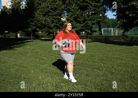 Une femme marche en toute confiance dans un parc avec un tapis d'exercice. Banque D'Images