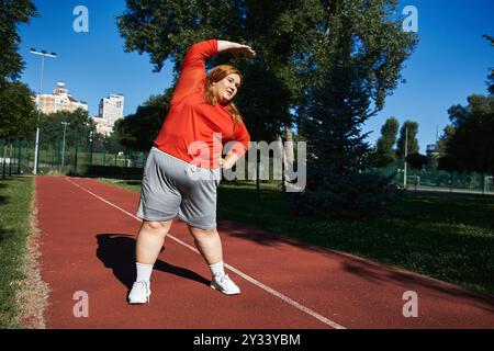 Une femme animée de plus grande taille aime s'étirer pendant qu'elle fait de l'exercice à l'extérieur. Banque D'Images