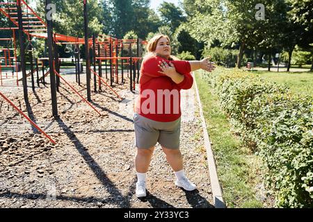 Une femme de grande taille aime s'étirer à l'air frais dans un parc. Banque D'Images