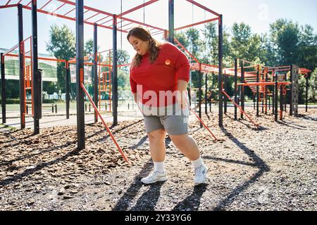 Une belle femme grande taille profite de son entraînement dans un parc ensoleillé. Banque D'Images