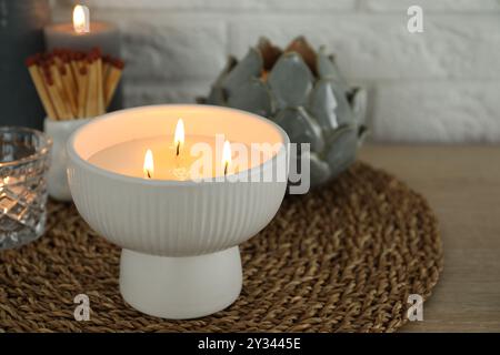 Bougies allumées et décor sur la table près du mur de briques blanches Banque D'Images