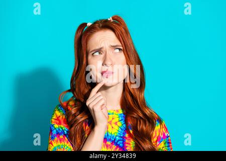 Portrait photo de jeune femme attrayante regarder l'esprit sceptique espace vide habillé vêtements colorés isolés sur fond de couleur cyan Banque D'Images