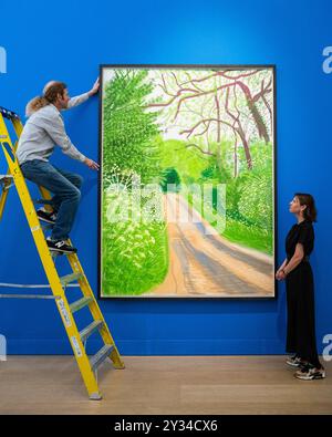 Londres, Royaume-Uni. 12 septembre 2024. Un technicien et un membre du personnel avec "L'arrivée du printemps à Woldgate, East Yorkshire en 2011 (vingt-onze) - 16 mai" par David Hockney (est. £280 000 - 400,0000 à un aperçu des œuvres à vendre par David Hockney à Phillips à Berkeley Square. Les lots seront mis aux enchères le 19 septembre. Credit : Stephen Chung / Alamy Live News Banque D'Images