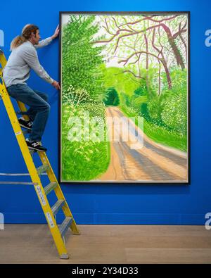 Londres, Royaume-Uni. 12 septembre 2024. Un technicien avec 'The Arrival of Spring in Woldgate, East Yorkshire in 2011 (vingt-onze) - 16 May' par David Hockney (est. £280 000 - 400,0000 à un aperçu des œuvres en vente par David Hockney à Phillips à Berkeley Square. Les lots seront mis aux enchères le 19 septembre. Credit : Stephen Chung / Alamy Live News Banque D'Images