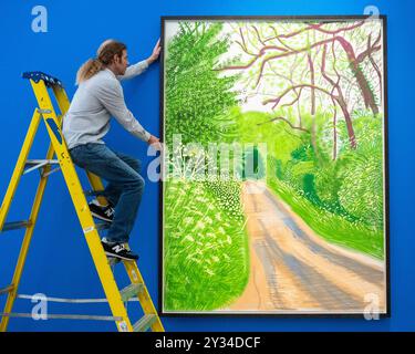 Londres, Royaume-Uni. 12 septembre 2024. Un technicien avec 'The Arrival of Spring in Woldgate, East Yorkshire in 2011 (vingt-onze) - 16 May' par David Hockney (est. £280 000 - 400,0000 à un aperçu des œuvres en vente par David Hockney à Phillips à Berkeley Square. Les lots seront mis aux enchères le 19 septembre. Credit : Stephen Chung / Alamy Live News Banque D'Images