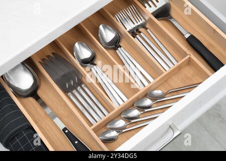 Boîte avec couverts dans le tiroir, gros plan. Rangement des ustensiles de cuisine Banque D'Images