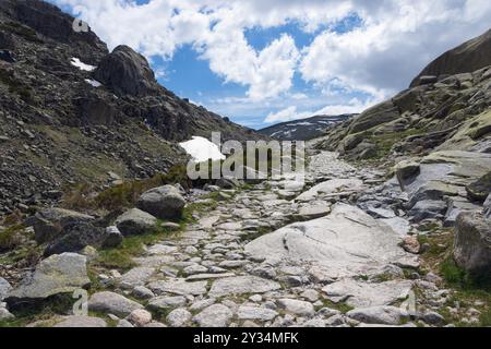 Un chemin pierreux serpente à travers un paysage de montagne rocheux sous un ciel nuageux, zone de randonnée, Reserva national de Gredos, Garganta de Prado Puerte, P. Banque D'Images