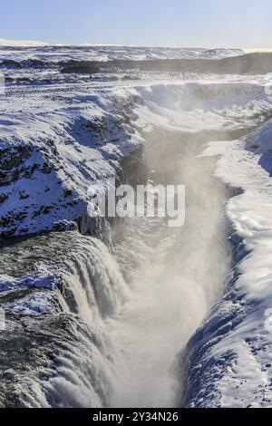 Grande cascade dans une gorge dans la neige, hiver, ensoleillé, contre-jour, spray, Gullfoss, cercle d'Or, Sud-Ouest de l'Islande, Islande, Europe Banque D'Images