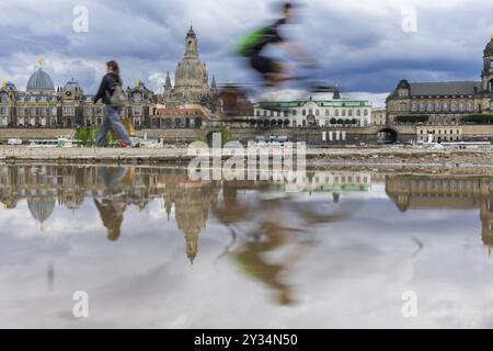 La silhouette de Dresde avec un cycliste et des nuages sombres derrière l'église notre-Dame se reflète dans une flaque sur la piste cyclable de l'Elbe, piste cyclable de l'Elbe, Banque D'Images