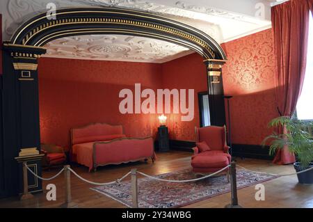 Chambre rouge avec une arche et des moulures dans le plafond Banque D'Images