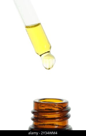 Goutte à goutte teinture de la pipette dans la bouteille sur fond blanc, gros plan Banque D'Images