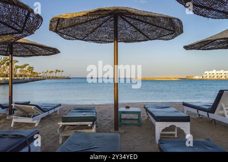 Transats et parasols sur une plage de la Mer Rouge à Hurghada Egypte Banque D'Images