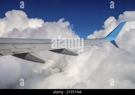 Ailes d'un avion dans un mélange de ciel ciel bleu et nuages Banque D'Images