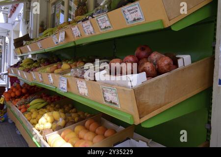 Présentation de boîtes de fruits frais à vendre avec citrons, oranges, bananes, kiwis, citrons verts Banque D'Images