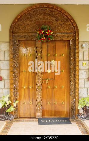 Arche en bois de style indien et porte d'entrée avec deux fenêtres et deux chaussures de pot de fleurs dans la ville de Nairobi, Kenya, Afrique Banque D'Images