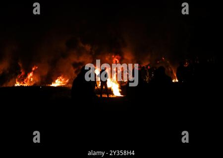 Gaza, Palestine, 26 février 2019. L'unité de la « confusion nocturne » a organisé une manifestation dans la zone de Malika à l'est de la ville de Gaza, près de la frontière avec Israël, levant les drapeaux palestiniens et incendiant des pneus. Certains Palestiniens de Gaza, connus sous le nom d'unité "confusion nocturne", ont commencé à organiser des manifestations nocturnes, au cours desquelles ils ont incendié des pneus et scandé des slogans pour protester contre le siège israélien serré de Gaza. Gaza connaît une crise humanitaire profonde, les jeunes étant confrontés à un avenir sombre de chômage et de manque de services de base tels que la santé, l'éducation, l'eau et l'électricité Banque D'Images