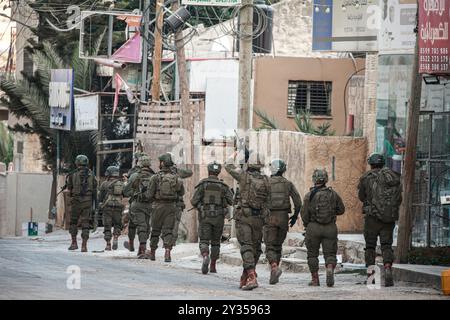 Tubas, Palestine. 11 septembre 2024. Un soldat israélien visant tandis que les autres descendent dans le centre-ville de Tubas lors du raid sur la ville de Tubas. Un raid militaire israélien de grande envergure contre la ville de Tubas, dans le nord de la Cisjordanie occupée, a permis de tuer cinq Palestiniens dans une frappe aérienne et les forces ont encerclé un hôpital palestinien et empêché le personnel médical de transporter des patients. (Photo de Nasser Ishtayeh/SOPA images/Sipa USA) crédit : Sipa USA/Alamy Live News Banque D'Images