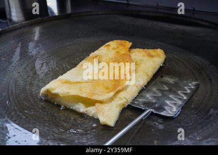 Faire frire Martabak Telor ou omelette martabak dans de l'huile chaude. Pâtisserie poêlée salée farcie d'oeufs, de viande et d'épices. En-cas traditionnels indonésiens Banque D'Images