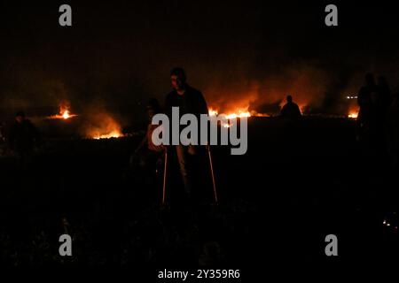 Gaza, Palestine, 26 février 2019. L'unité de la « confusion nocturne » a organisé une manifestation dans la zone de Malika à l'est de la ville de Gaza, près de la frontière avec Israël, levant les drapeaux palestiniens et incendiant des pneus. Certains Palestiniens de Gaza, connus sous le nom d'unité "confusion nocturne", ont commencé à organiser des manifestations nocturnes, au cours desquelles ils ont incendié des pneus et scandé des slogans pour protester contre le siège israélien serré de Gaza. Gaza connaît une crise humanitaire profonde, les jeunes étant confrontés à un avenir sombre de chômage et de manque de services de base tels que la santé, l'éducation, l'eau et l'électricité Banque D'Images