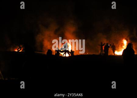 Gaza, Palestine, 26 février 2019. L'unité de la « confusion nocturne » a organisé une manifestation dans la zone de Malika à l'est de la ville de Gaza, près de la frontière avec Israël, levant les drapeaux palestiniens et incendiant des pneus. Certains Palestiniens de Gaza, connus sous le nom d'unité "confusion nocturne", ont commencé à organiser des manifestations nocturnes, au cours desquelles ils ont incendié des pneus et scandé des slogans pour protester contre le siège israélien serré de Gaza. Gaza connaît une crise humanitaire profonde, les jeunes étant confrontés à un avenir sombre de chômage et de manque de services de base tels que la santé, l'éducation, l'eau et l'électricité Banque D'Images