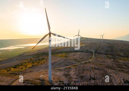 ÎLE DE Pag, CROATIE - 14 JUILLET 2024 : grandes éoliennes montées sur la colline de l'île de Pag au coucher du soleil. Innovation pour transformer l’éolien en source durable d’énergie électrique écologique en Croatie Banque D'Images