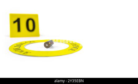 Une enveloppe de balle usagée placée dans un cercle jaune, étiquetée avec le texte « preuves, ne bougez pas », avec une étiquette de numéro 10 floue, placée sur un blanc Banque D'Images