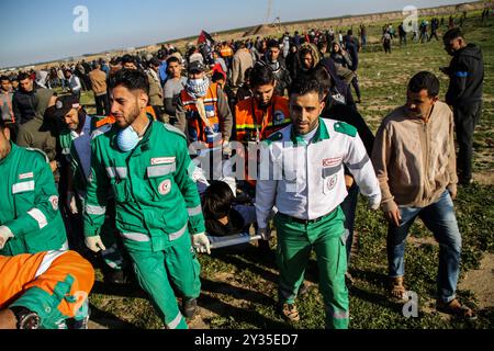 Gaza, Palestine, 8 mars 2019. Des manifestants palestiniens brûlent des pneus et brandissent le drapeau palestinien, quelques pierres lançant vers la clôture, dans la zone de Malika, à l'est de la bande de Gaza. Des manifestants palestiniens s’étaient rassemblés sur différents sites le long de la frontière Gaza-Israël lors de ce vendredi 50ème rassemblement de la Grande Marche du retour, et selon le ministère de la santé à Gaza cinq Palestiniens ont été blessés en ce vendredi mars, dont un dans un état critique. Selon l’armée israélienne, des ballons incendiaires transportant des explosifs ont été lâchés de la bande de Gaza dans le sud d’Israël. La plus haute Comm Banque D'Images