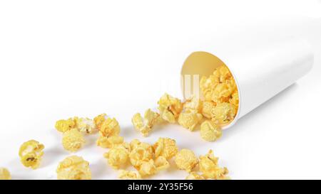 Image isolée de pop-corn dans une tasse en papier sur fond blanc, mettant en valeur les grains moelleux et dorés débordant sur les bords, parfait pour eux Banque D'Images