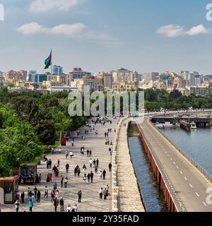 Bakou, Azerbaïdjan - 4 mai 2024 : les gens se promènent le long du boulevard Bakou, profitant de l'air frais et des vues pittoresques sur le front de mer et le paysage urbain animé sous un ciel dégagé Banque D'Images