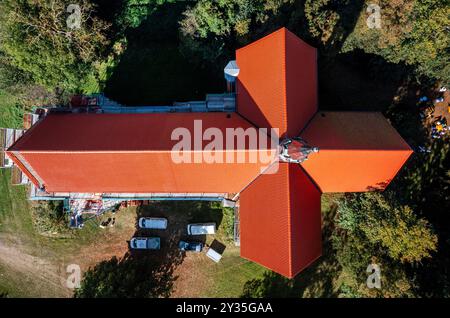 Neukloster, Allemagne. 12 septembre 2024. L'échafaudage autour de l'église est toujours debout et le toit de l'église du monastère a été entièrement recouvert de tuiles de moine et de nonne ces derniers mois. L'église, qui est également célèbre pour ses vitraux médiévaux (datant d'environ 1250), a été largement rénovée et restaurée au cours des dix dernières années en plusieurs phases de construction. La construction extraordinaire de toiture du 13ème siècle avec des poutres en bois qui ont environ 800 ans a ainsi été préservée. Crédit : Jens Büttner/dpa/Alamy Live News Banque D'Images