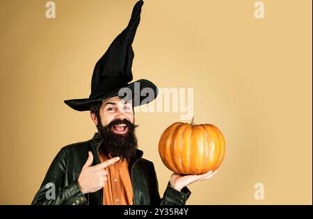 Homme barbu cuisez dans un chapeau d'Halloween avec de la citrouille. Joyeux week-end d'Halloween. Trick or Treat. Autocollants Happy Halloween. Joyeux Halloween - beau homme Banque D'Images