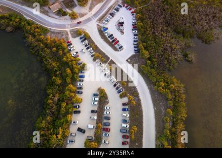 Vue aérienne des voitures garées sur le parking de la plage de l'océan. Vacances en bord de mer dans le sud de la Floride Banque D'Images