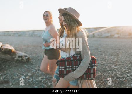 Un groupe de trois femmes marchant ensemble vers la plage. Banque D'Images