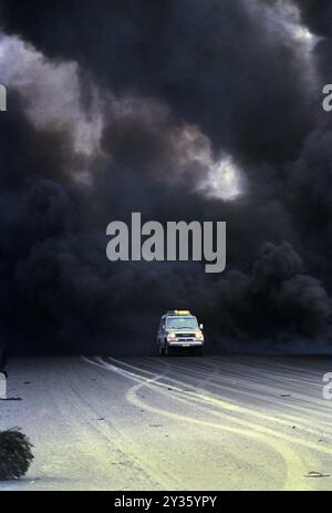 Première Guerre du Golfe : 7 mars 1991 Une Toyota Landcruiser émerge de la fumée noire qui jaillit des puits de pétrole sabotés dans le champ pétrolier de Burgan, au sud de Kuwait City. Banque D'Images