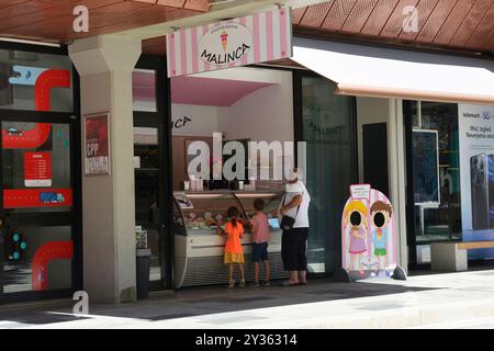 Nova Gorica, Slovénie - 7 septembre 2024. Un père achète la crème glacée de ses enfants sur la rue Bevkov trg dans le centre de Nova Gorica par une chaude journée d'été Banque D'Images