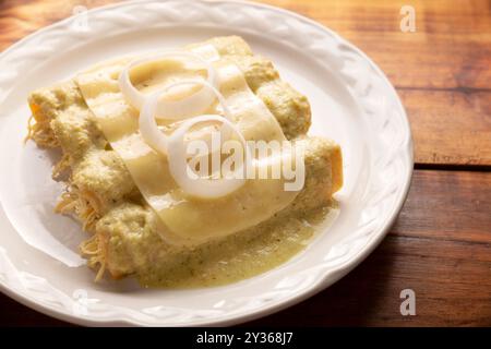 Cuisine mexicaine. Enchiladas à la sauce verte crémeuse remplie de viande de poulet râpée et recouverte de fromage fondu, au Mexique, ils sont appelés Swiss ENC Banque D'Images